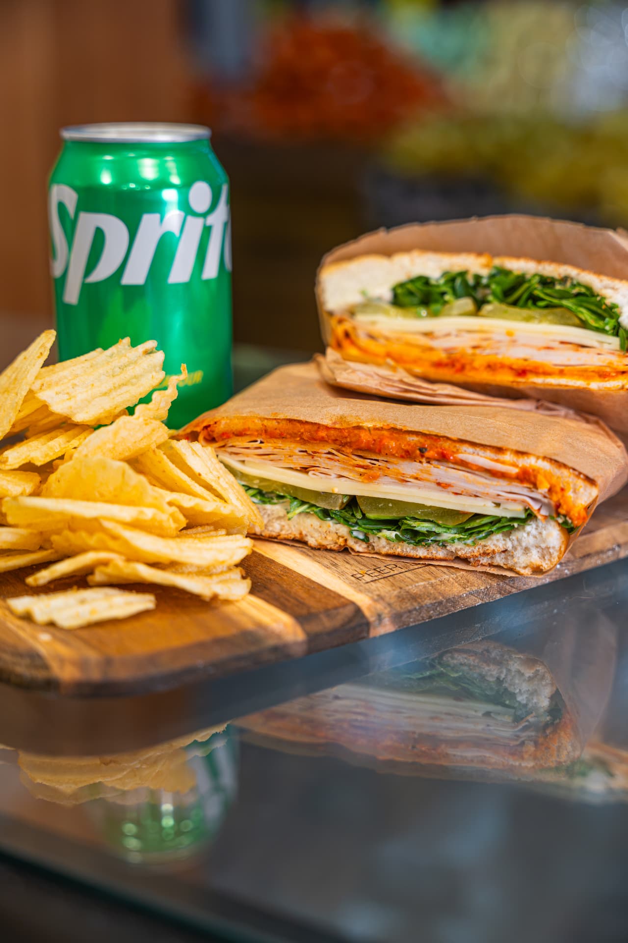 Focaccia sandwich with a side of potato chips and a canned drink