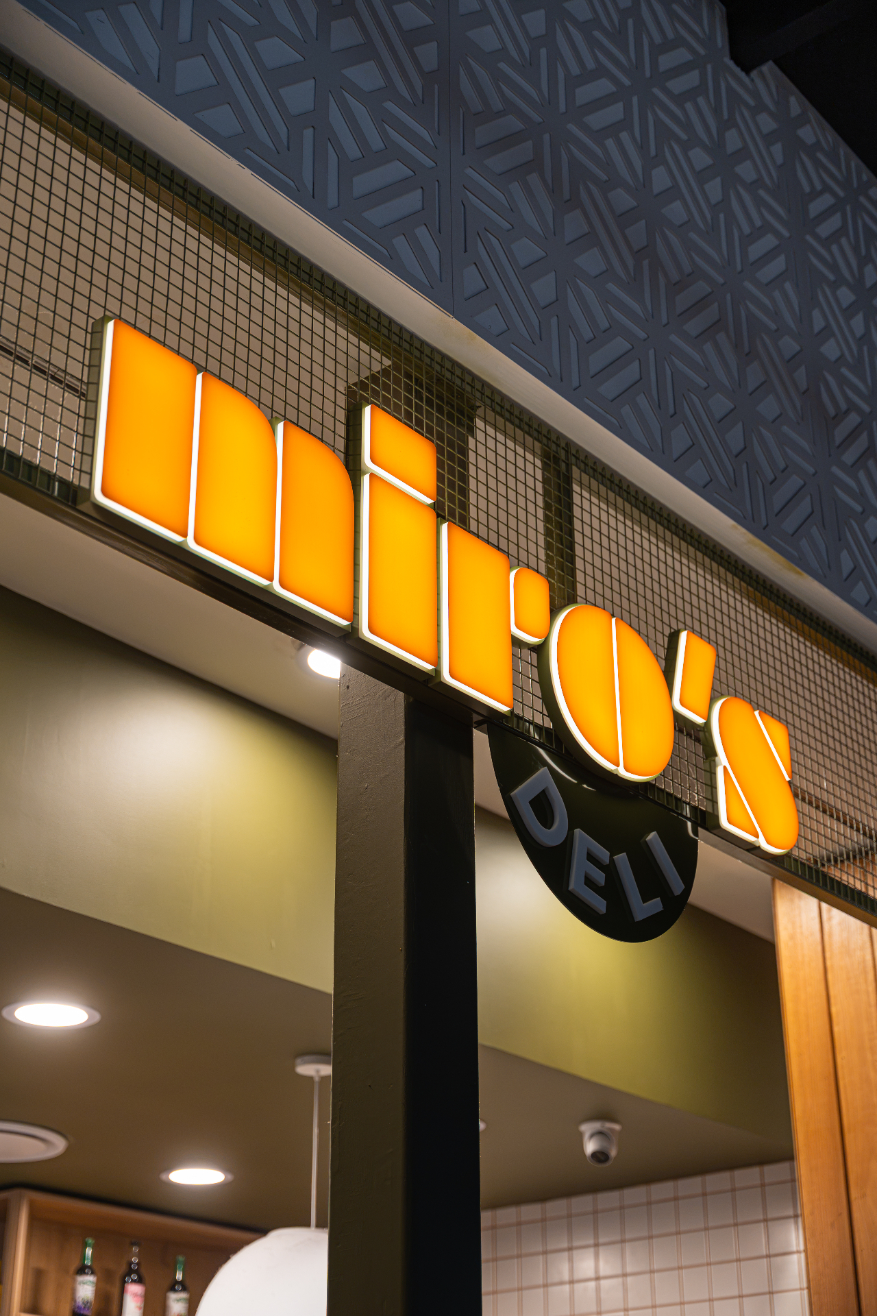The warm glow of Miro's Deli neon storefront sign at dusk.