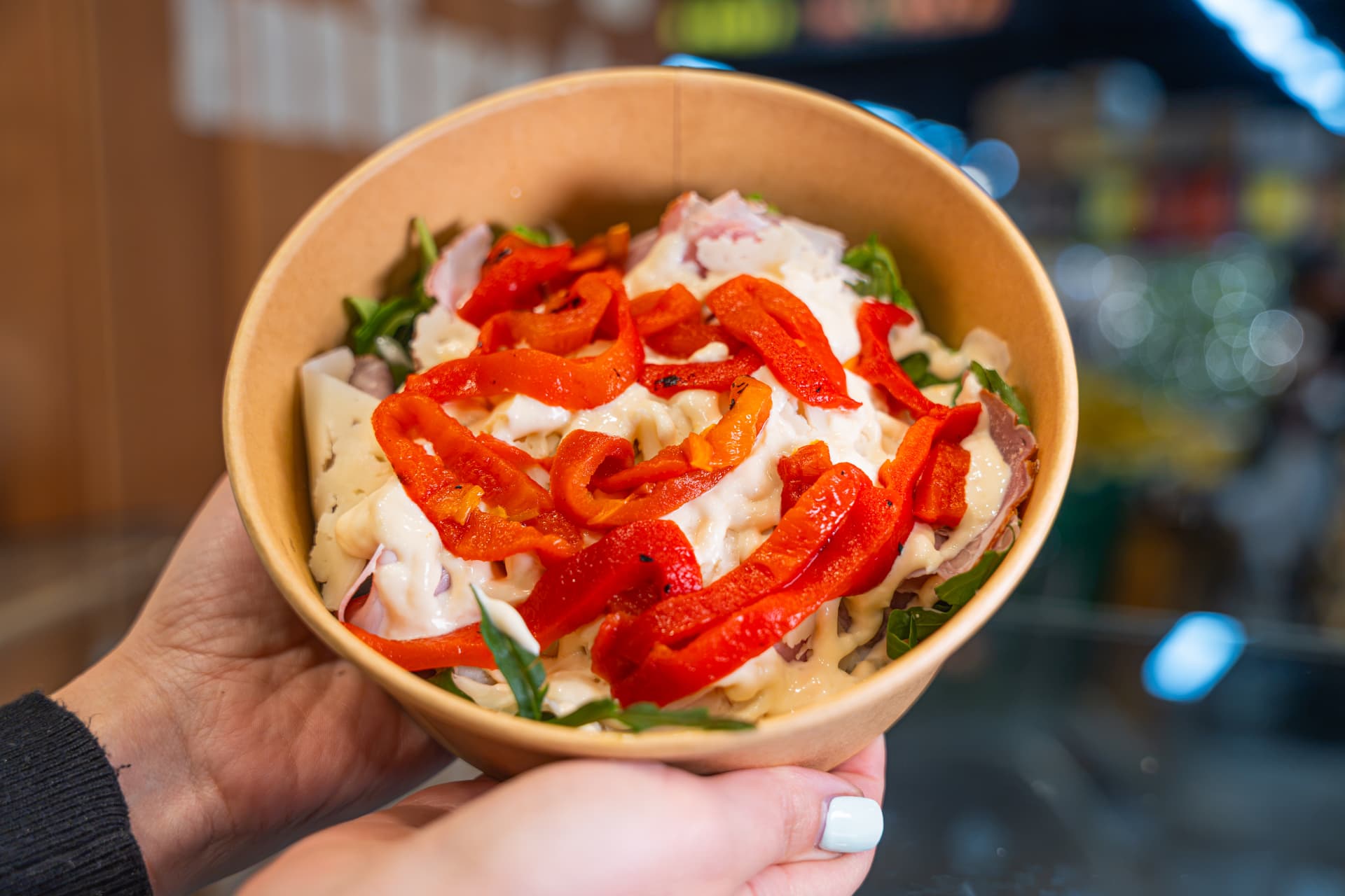 Deli bowl with sliced meats, cheese, rocket and roasted capsicum